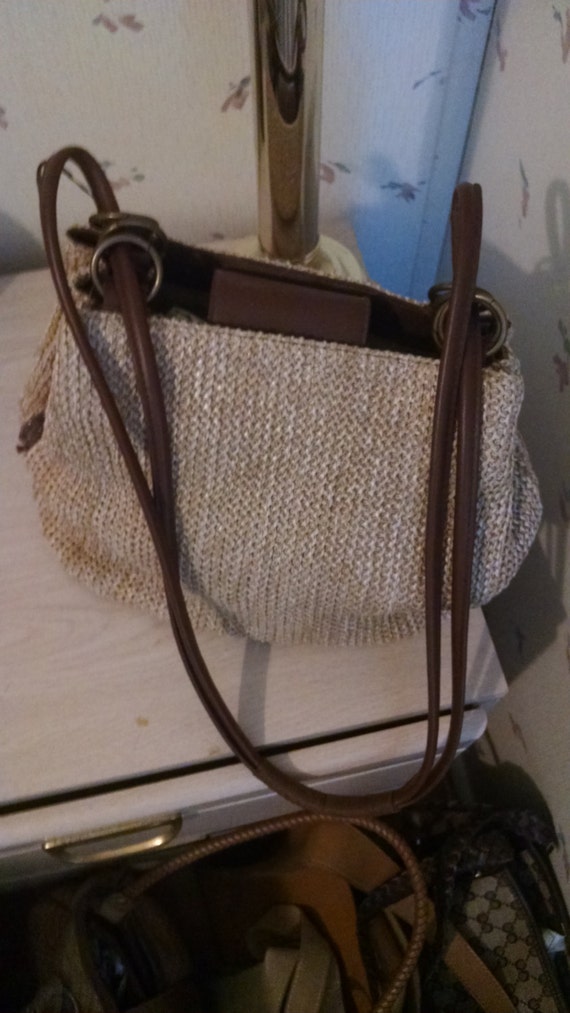 Roomy straw with brown leather straps bag.