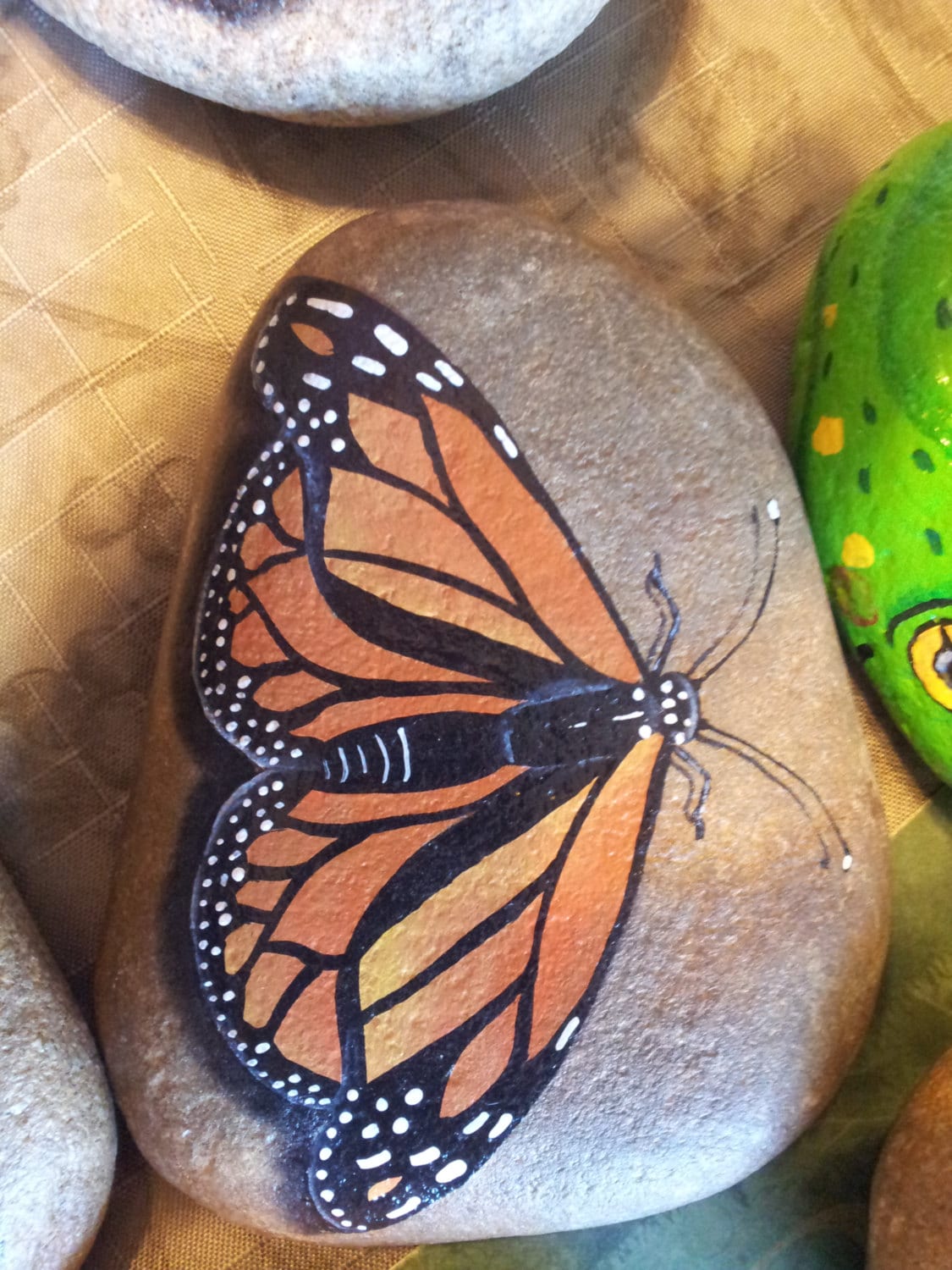 Monarch Butterfly hand painted on river rock by Dreampaintersofsm