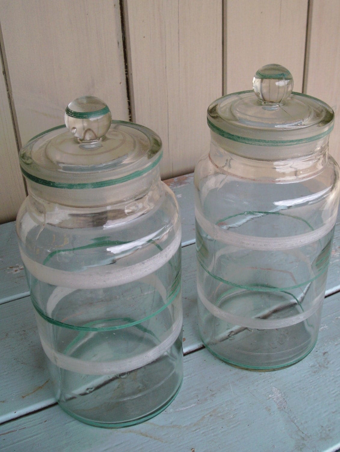 Pair of vintage glass storage jars with handpainted bands in