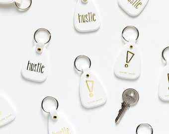 hustle key chain - shiny gold text