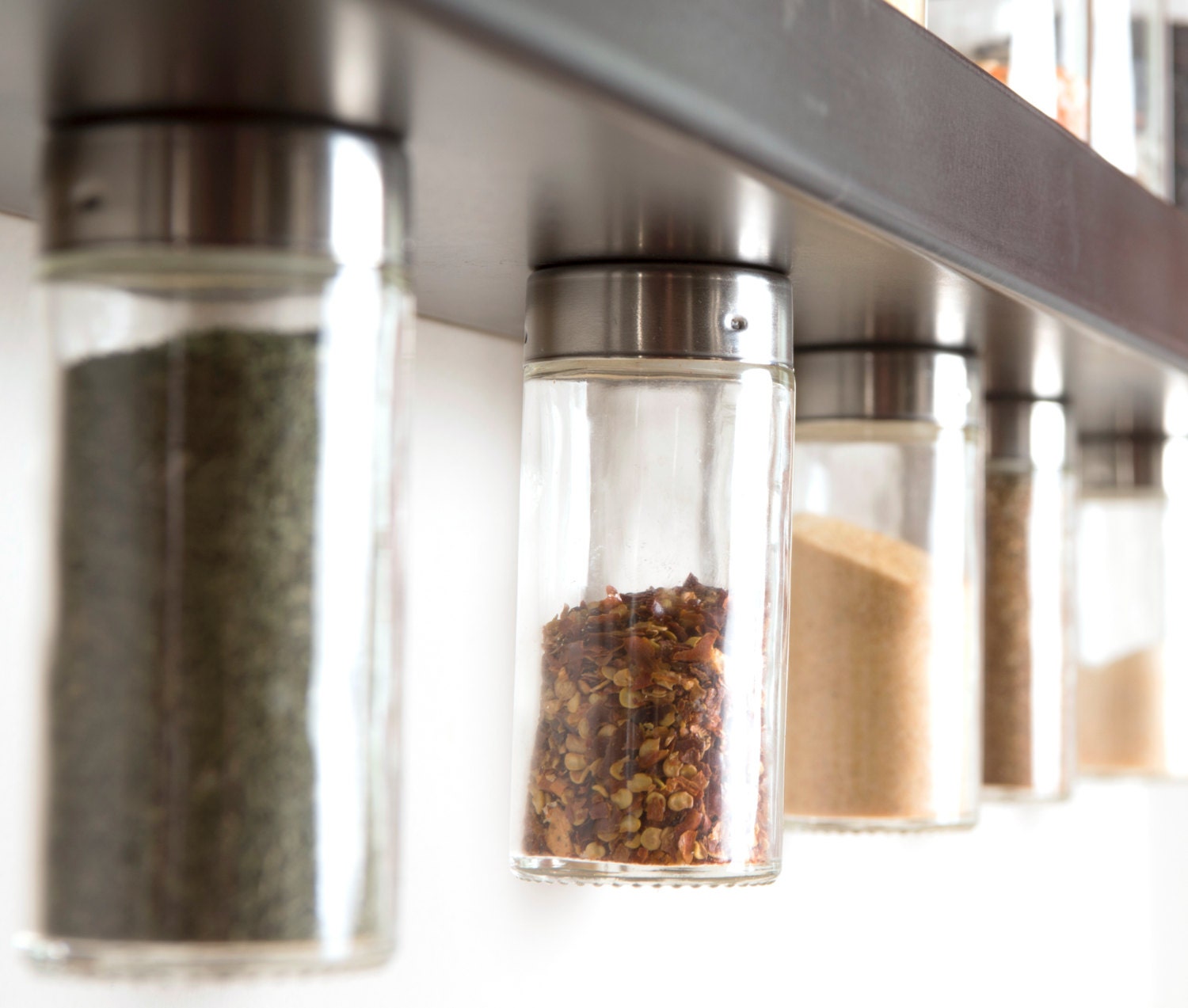 Four glass spice jars with lids