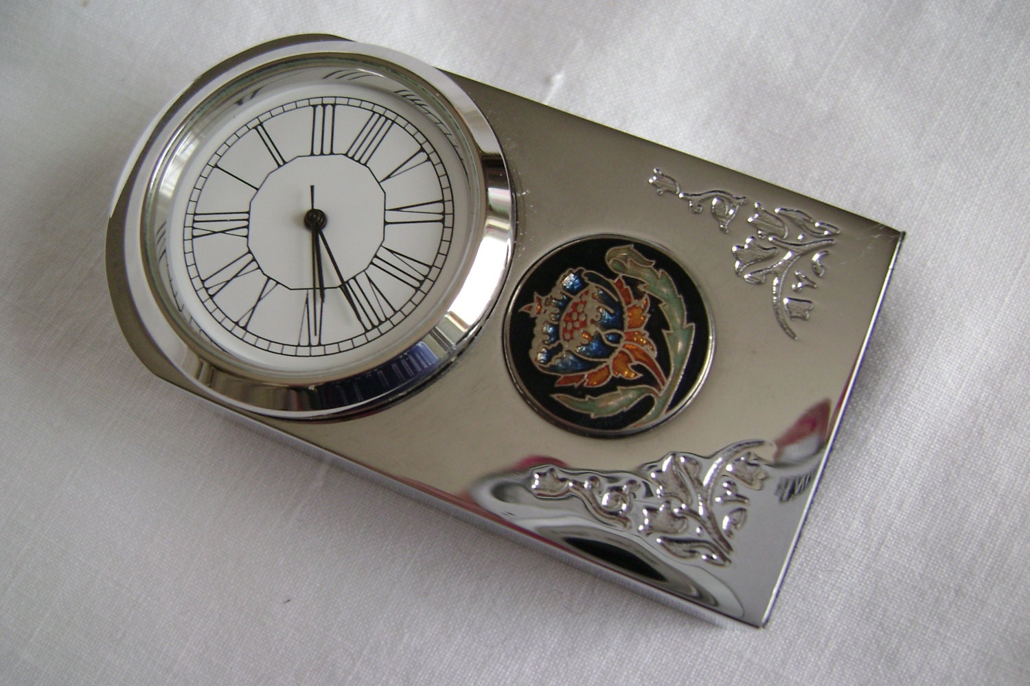 Small decorative chrome mantel clock with circular enamel
