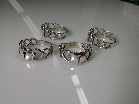 Elegant Sterling Silver heart ring. These rings features 4 hallow hearts on the sides with a solid key lock heart design on top.