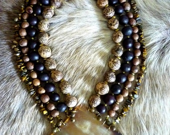 Collier plastron 4 rangs en corne, graines, pierres et grelots