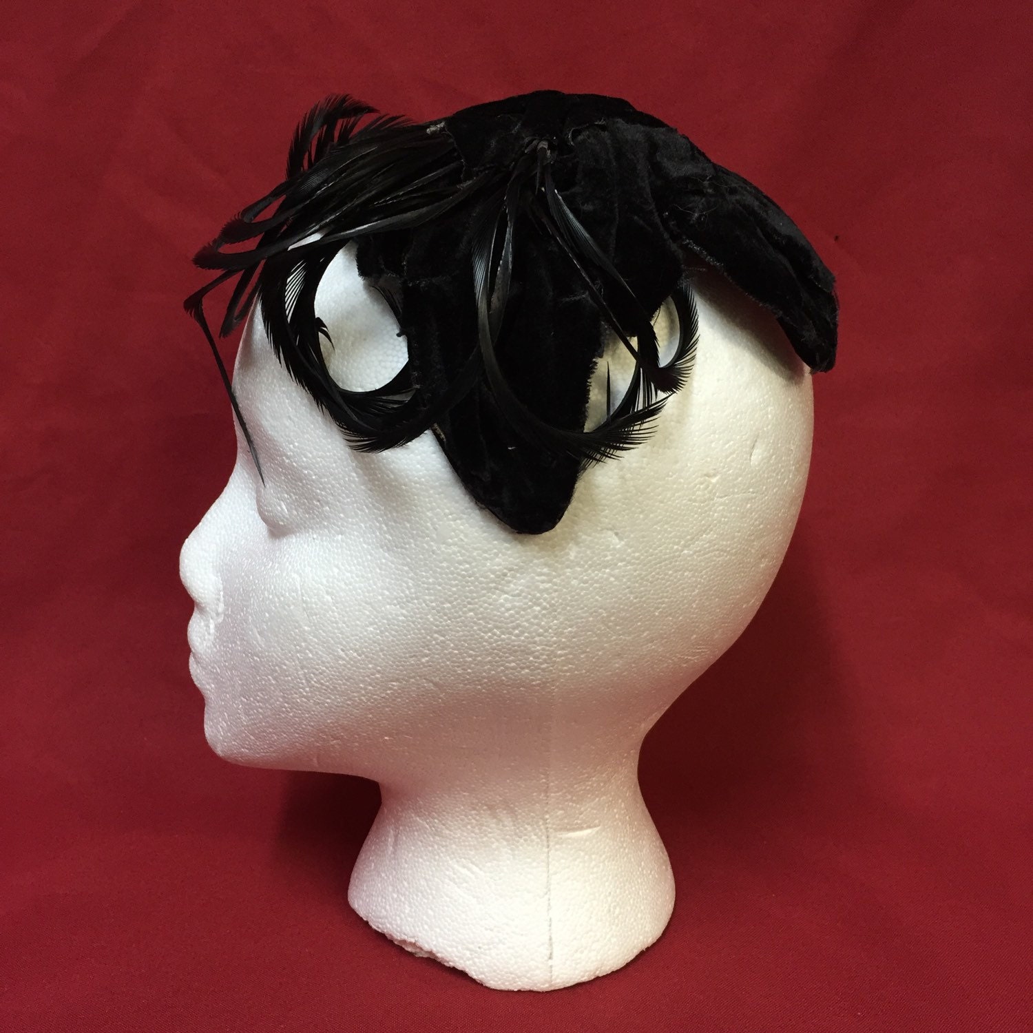 Ladies solid black velvet skull cap hat with black feathers.