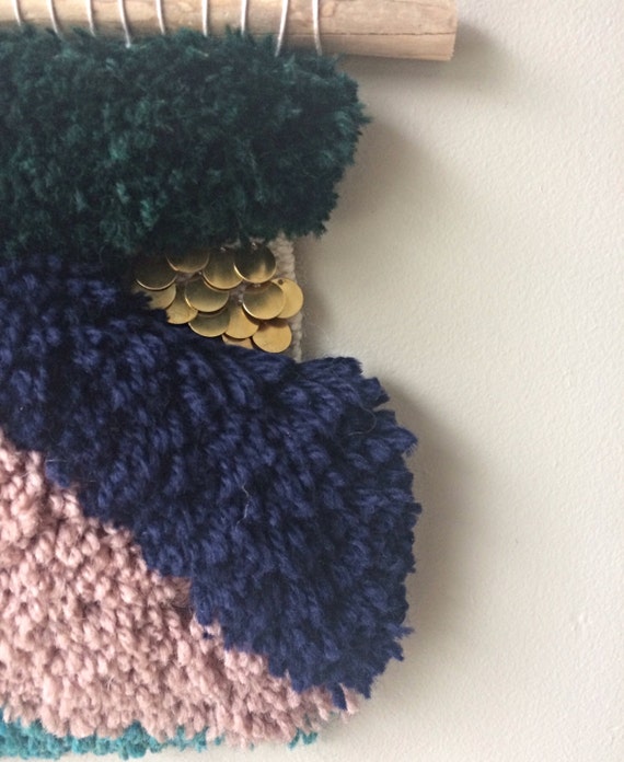 Hand woven wall hanging with raw brass navy and teal blues