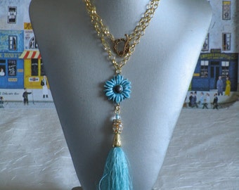 Charmant collier avec pendentif en céramique "Une gerbéra turquoise et un pompon"