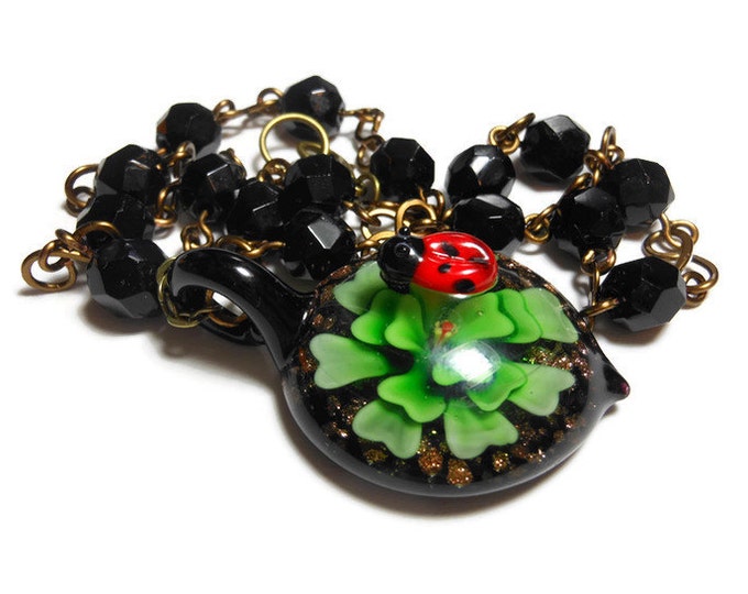 Lampwork ladybug necklace, ladybug on top of a green flower pendant, vintage black wire wrapped faceted glass beads, handmade infinity links