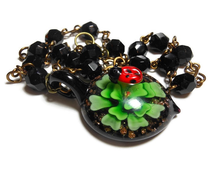 Lampwork ladybug necklace, ladybug on top of a green flower pendant, vintage black wire wrapped faceted glass beads, handmade infinity links