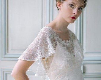 Vintage inspired lace wedding dress sample with flutter sleeve, low V back, flowing skirt and short train.