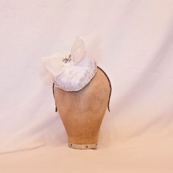 Handmade white heart shaped hat with a white lace overlay and bow and jewel detailing