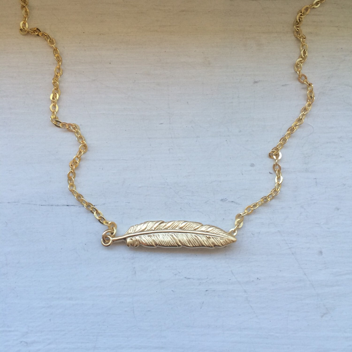 Feather necklace gold plated horizontal feather sideways