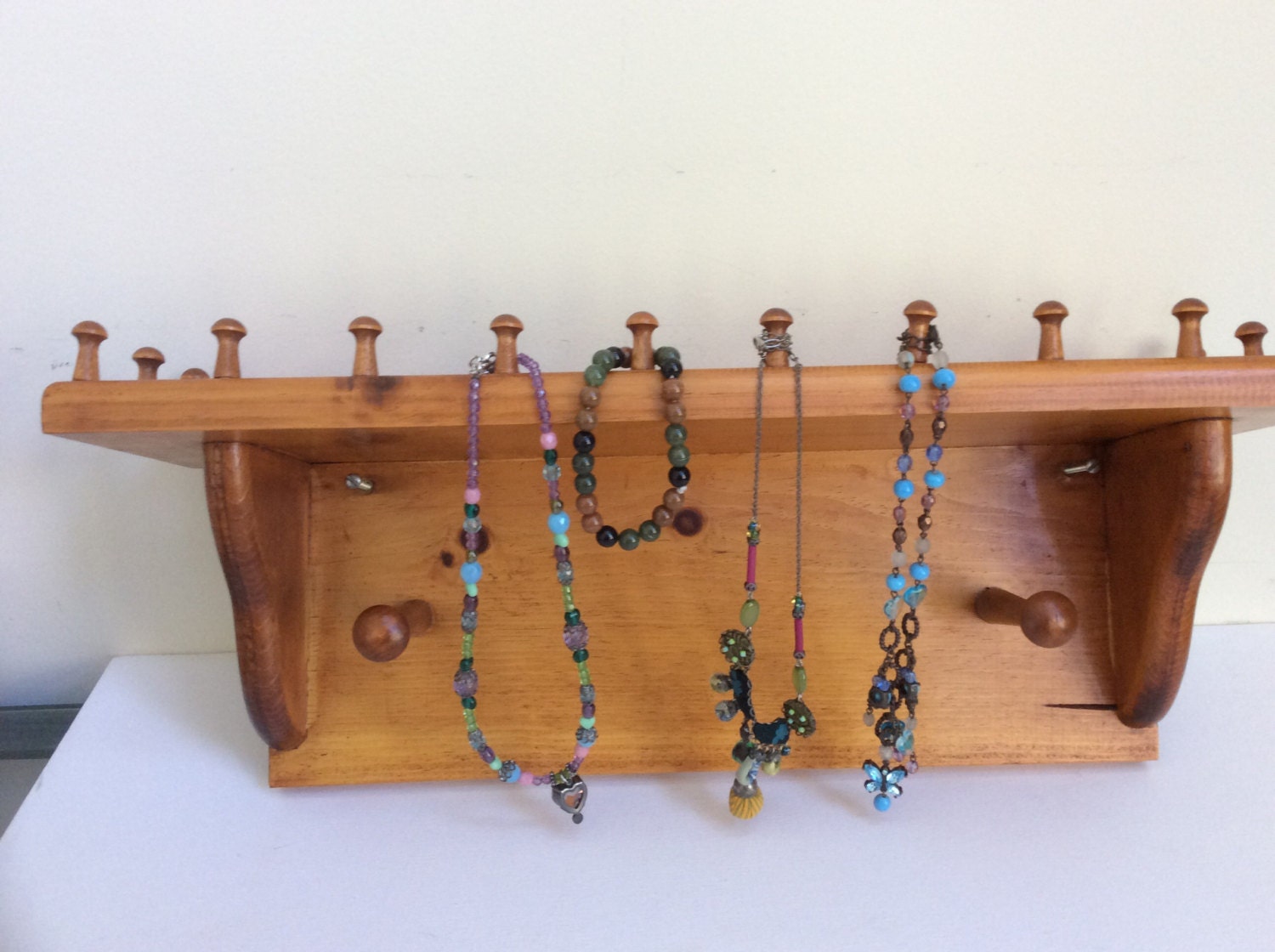 Vintage wooden wall shelf with pegs. Rustic Jewelry storage