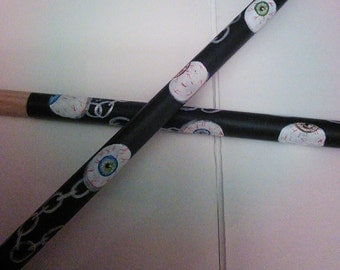 Drum sticks with a eyeball and chain theme