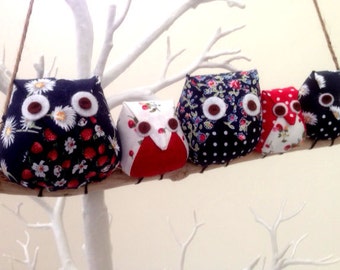 Owl family on a branch, 5 red,blue and white owls