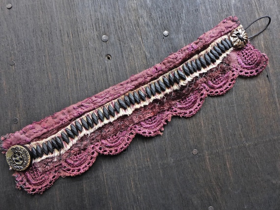 Chthonic. Primitive textile stitched bracelet with antique jet nailheads in plum.