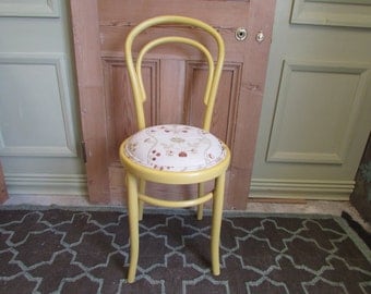 A yellow painted bentwood dining chair