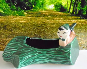 Vintage, 1940-50s Pixie/ Elf/ gnome planter. Pixie is laying on a green log that forms a small planter, garden planter.