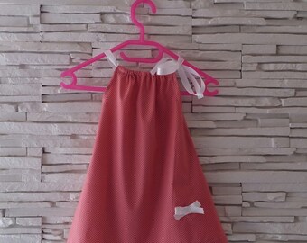 Robe bébé ruban rose à petits pois blanc.