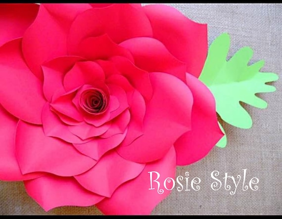 A close-up of the layers of red paper used to create a giant Rosie-style paper flower with paper leaves. The text in the right corner reads "Rosie Style." 