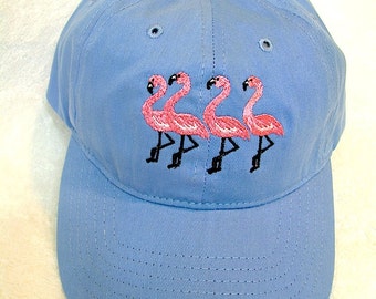 Four Flamingos on a Blue Baseball Cap. Flamingo Pink Flamingos Embroidered on a Blue Baseball Cap. Happy Flamingos on a Baseball Cap