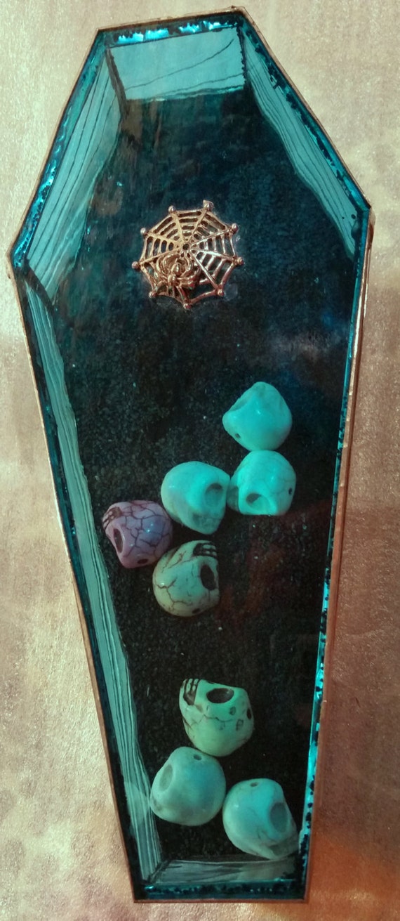 Stained glass sealed coffin with skulls inside. Embellished