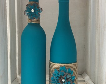 Teal chalk painted wine bottles with twine and metal flowers