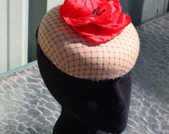 Camel pillbox hat , this smart felt hat is decorated with a large red silk poppy and black net