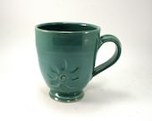 green mug with a flower