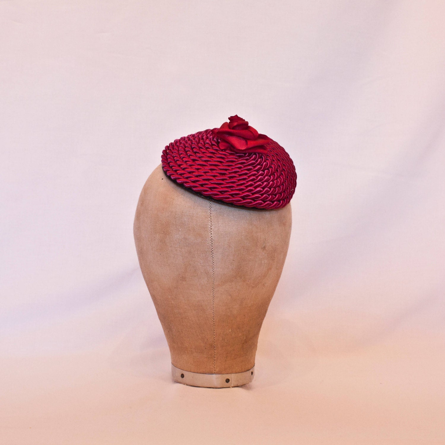 Handmade raspberry red cord fascinator decorated with a handmade ribbon rose