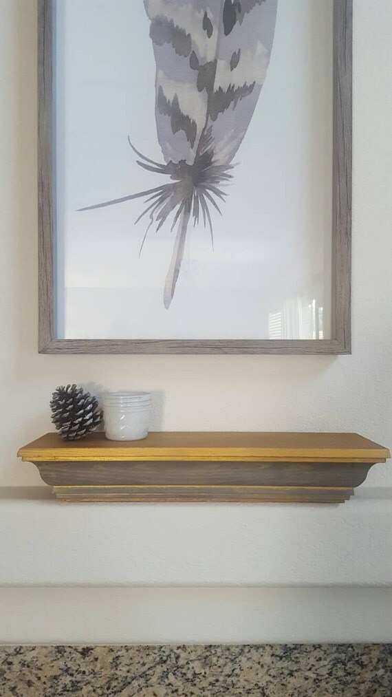 Weathered gray wood shelf with antique metallic touches