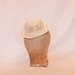 Small ivory bowler hat shaped fascinator with veiling and pearl bead detailing