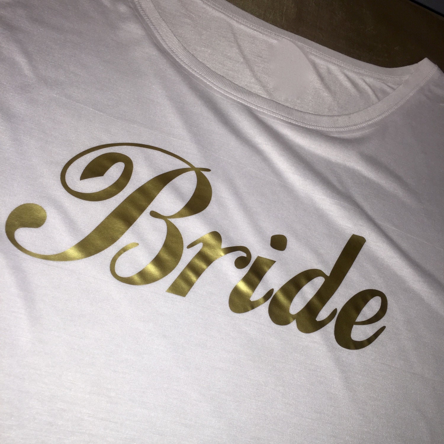white t shirt gold writing