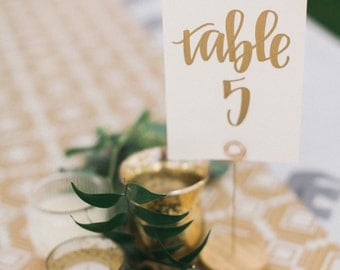 gold calligraphy wedding table numbers // handwriting in calligraphy font for wedding decor // table signs for wedding guest tables