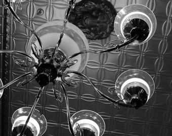 Framed fine art photograph, black and white, light fixture, antique ceiling tiles, metal, glass globes, lion face