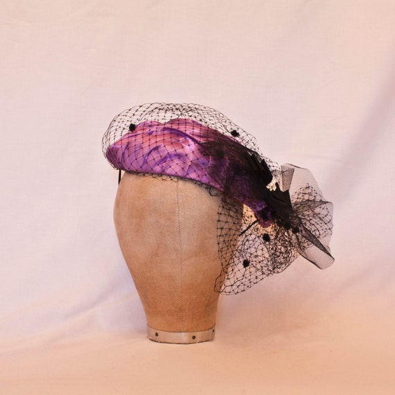 Handmade satin hat in clover purple decorated with polka dot spotted veiling and diamanté detail