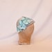 Handmade pale blue ladies occasion hat, decorated with delicate blue flowers