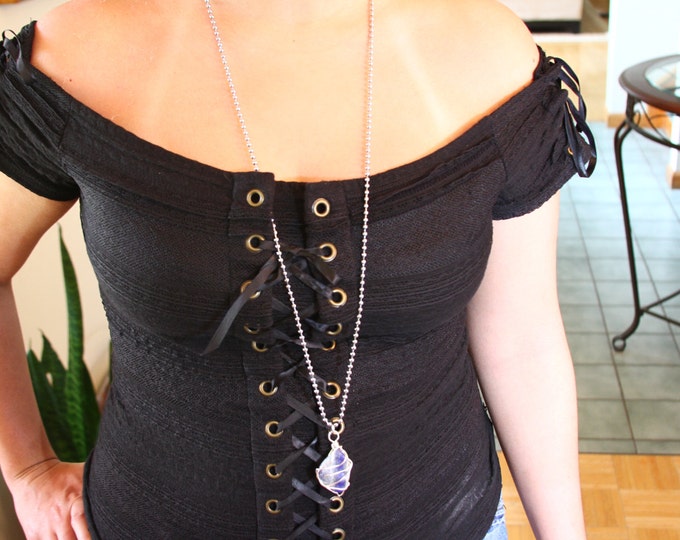 Raw Lapiz lazul gemstone in a silver cage long necklace.