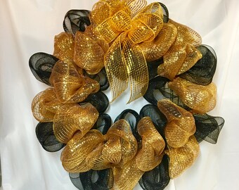 Team or school gold and black mesh wreath. Metallic gold, black mesh on 18" wire frame. 22" wreath. Metallic gold mesh bow. Chenille hanger