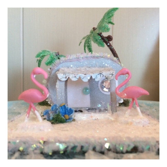 Miniature kitsch glitter house trailer with palm trees and yard flamingos