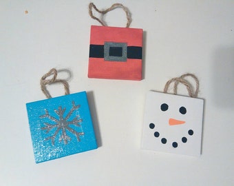 Set of three Christmas ornaments: Santa Claus, snowman, & snowflake