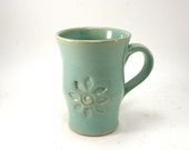 green mug with a flower