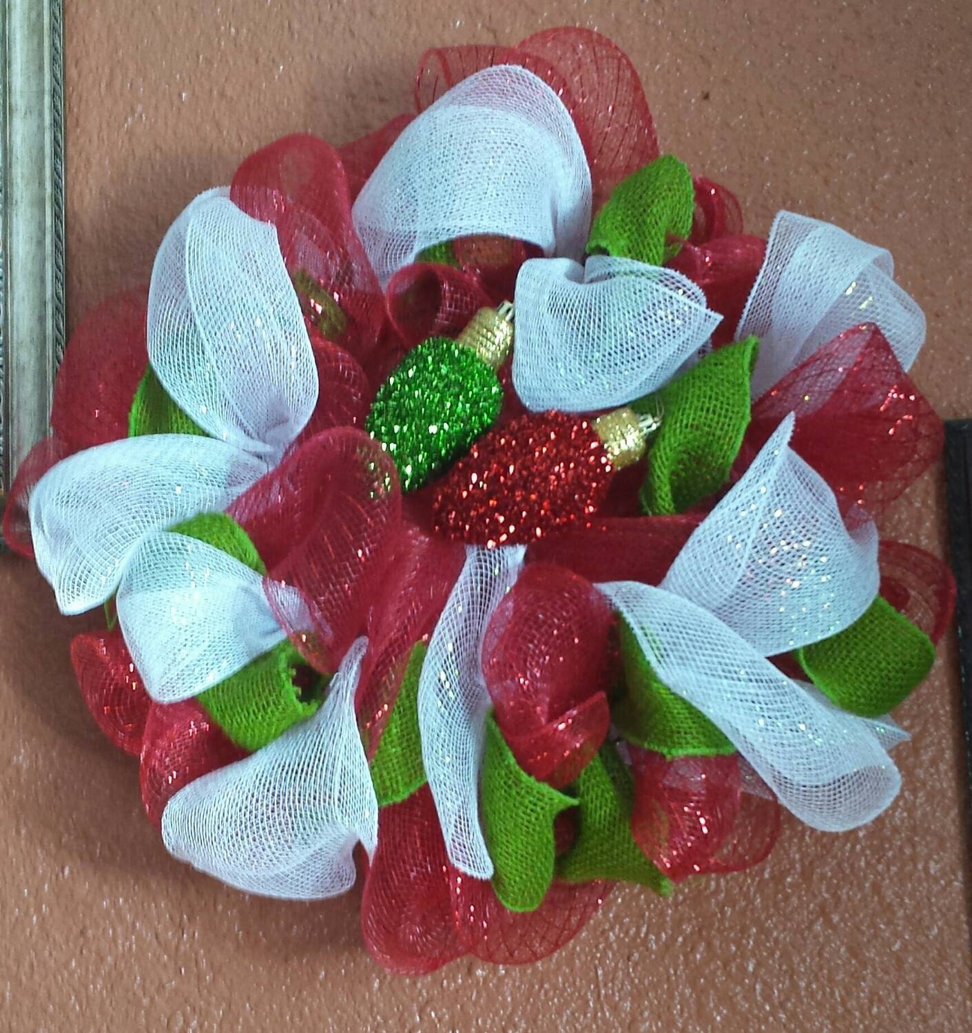 Red, green, and white, ornament embellished medium sized Christmas wreath.