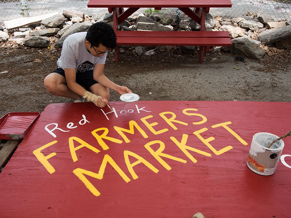Un empleado de Etsy pinta un letrero para el Red Hook Farmers Market Un empleado de Etsy pinta un letrero para el Red Hook Farmers Market