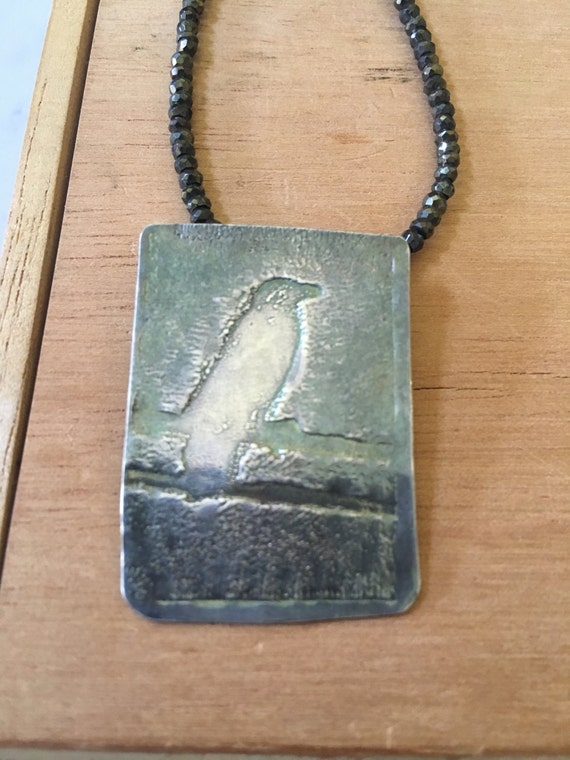 Photo etched fine silver crow on a pyrite necklace; chain length 20 inches (adjustable)