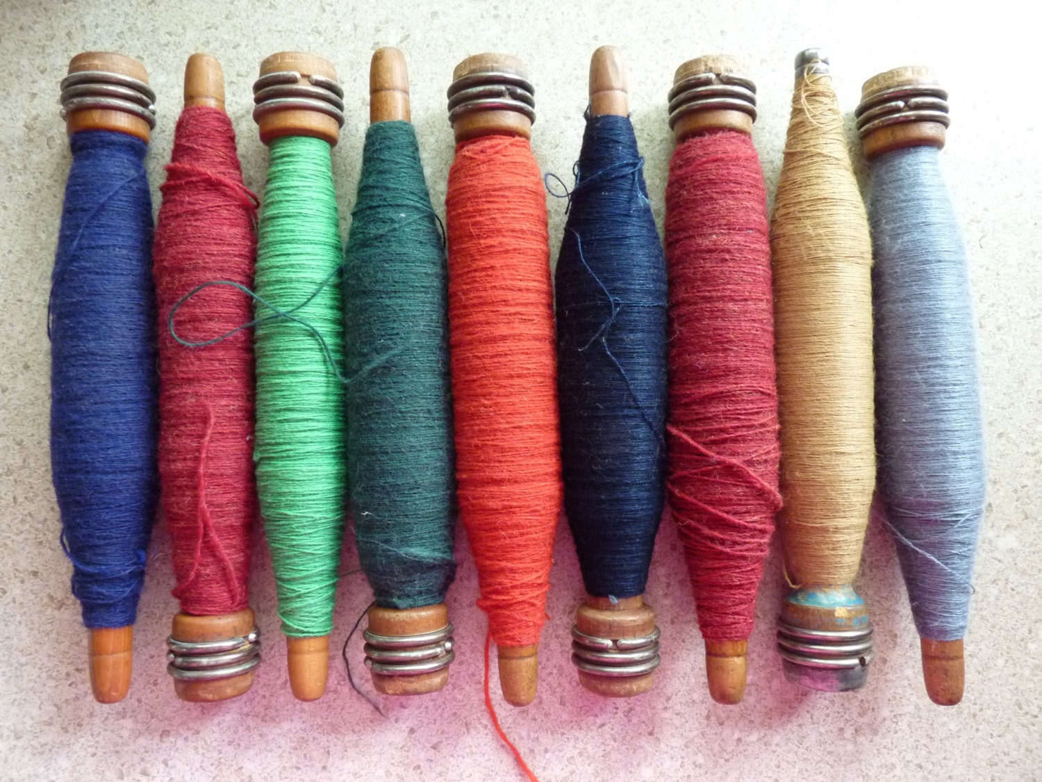 Nine Wooden Bobbins Filled With Weaving Threadyarn