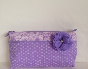 Purple two-toned cosmetic bag, make-up bag, zippered pouch, storage bag with a flower accent.