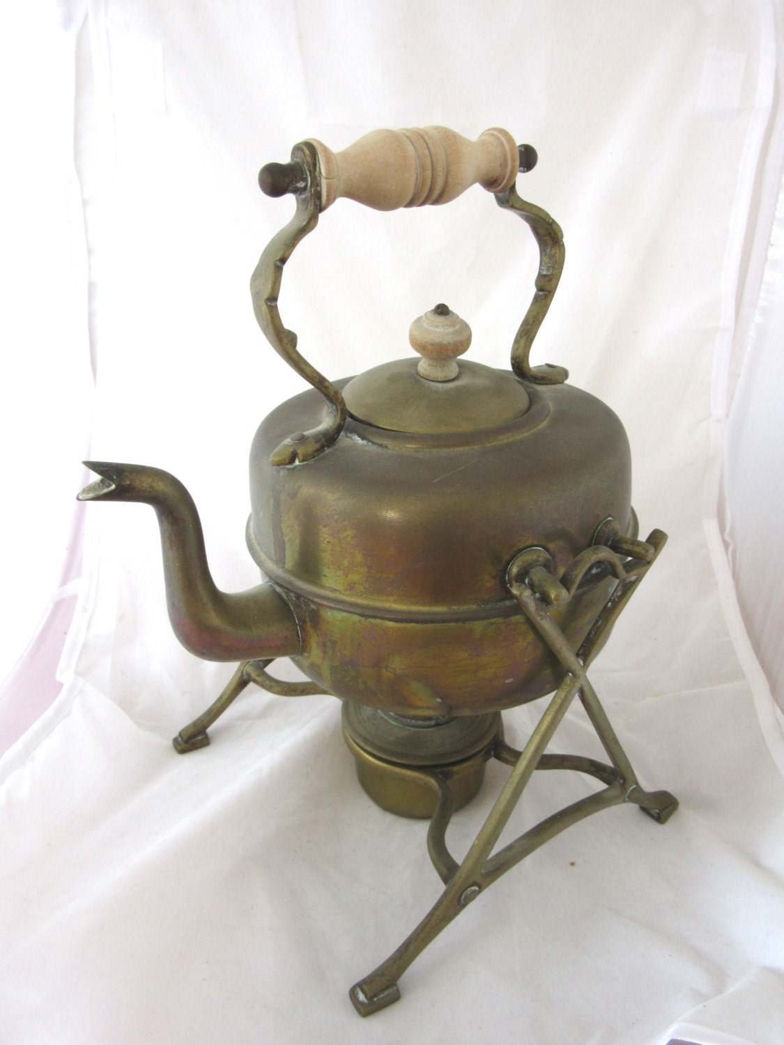 Antique vintage brass kettle on a stand with a heating stove