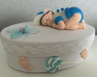 Baby produced in polymer asleep on a box decorated with