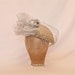 Beautiful handmade ladies occasion hat in pale gold and silver, decorated with handmade ribbon roses, veiling and tulle